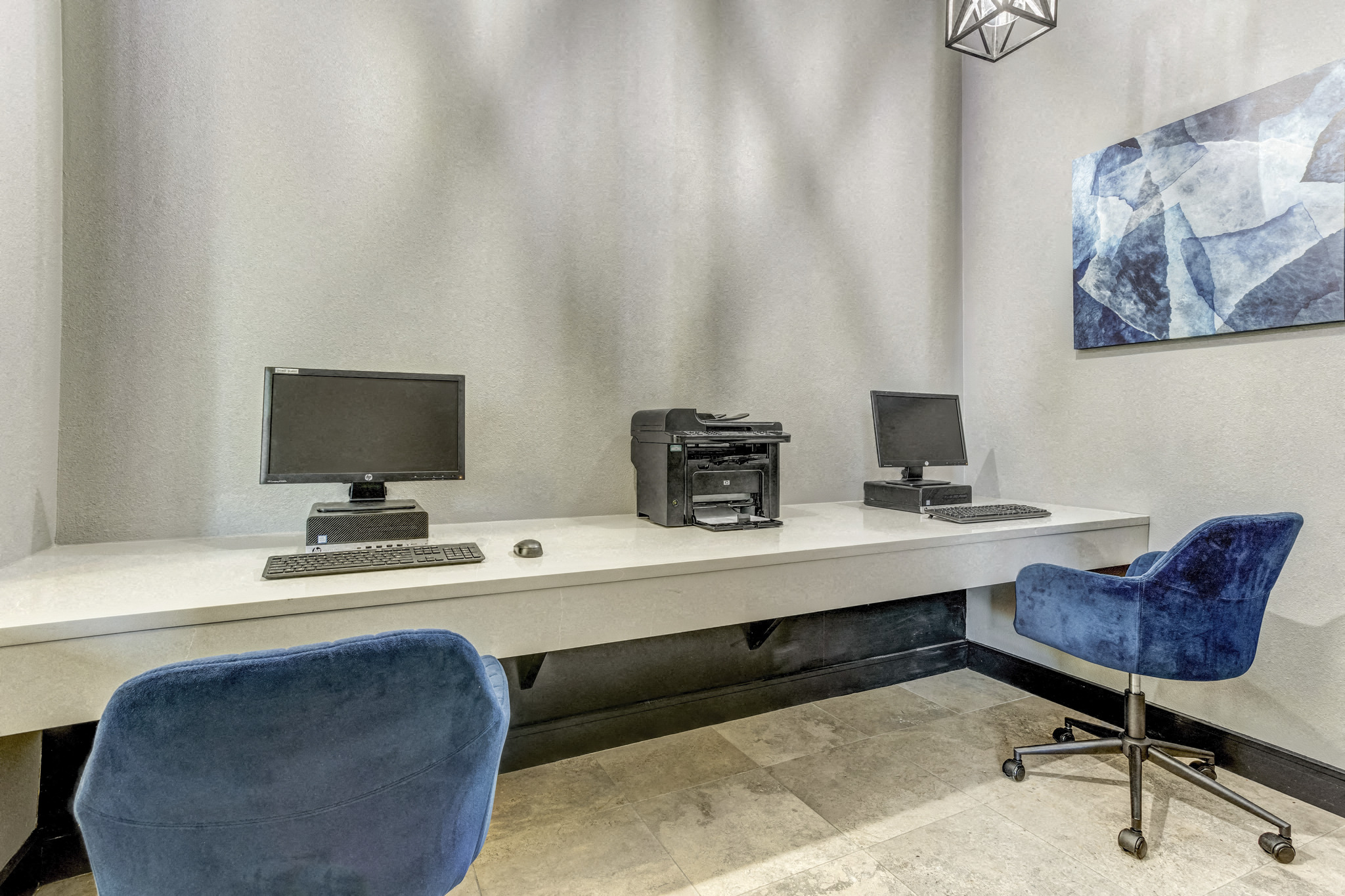 two desks with computers and chairs in a room
