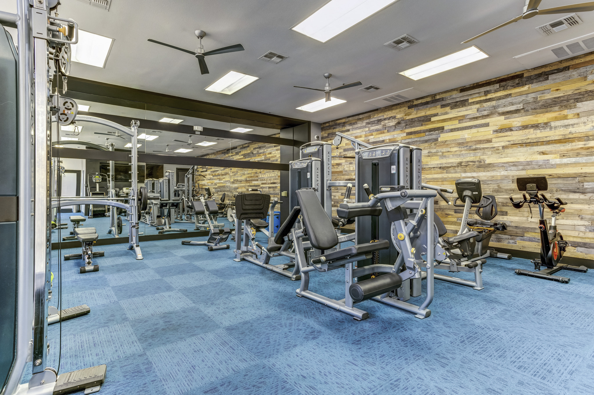 a gym with weights and cardio equipment in a building with brick walls