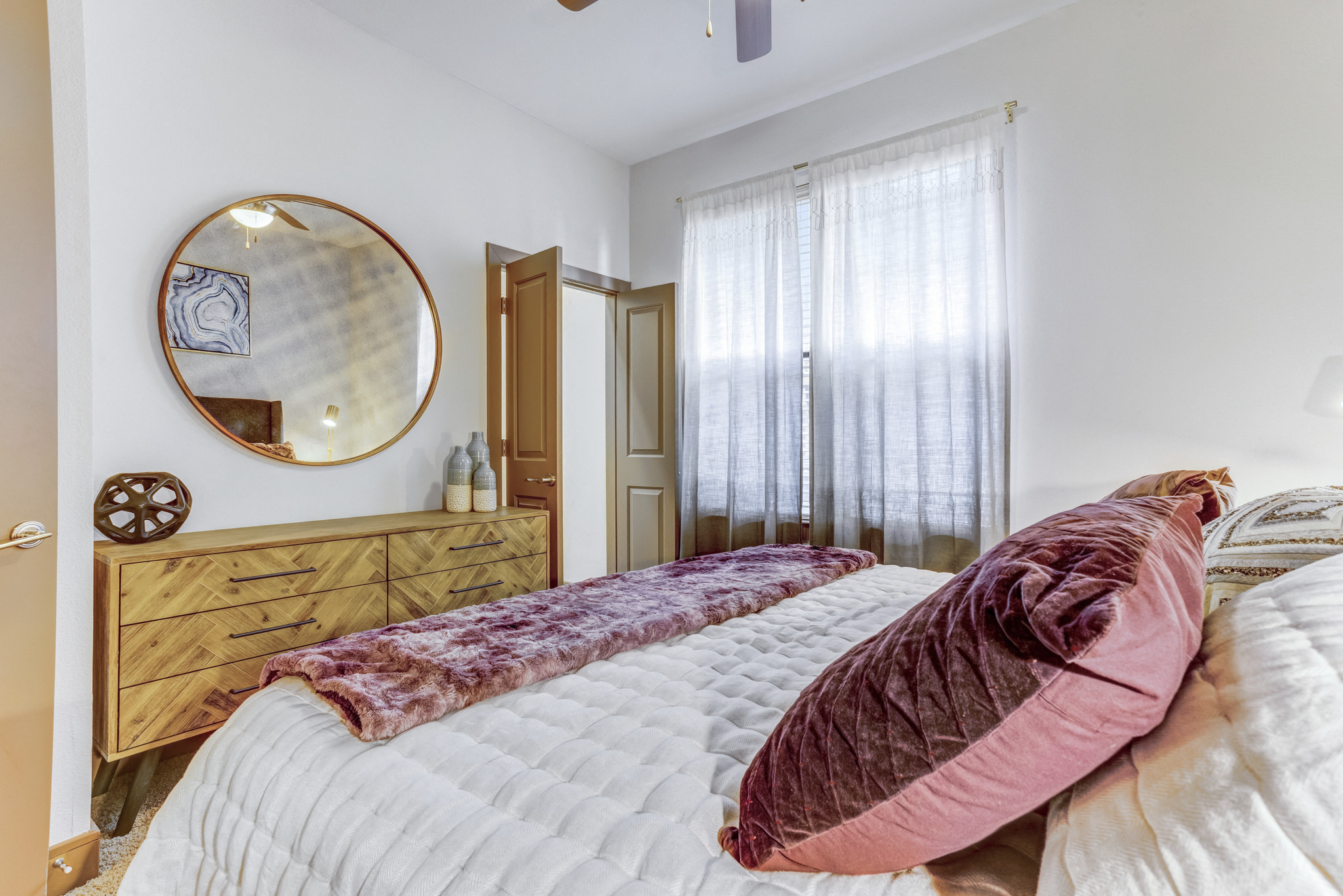 a bedroom with a large bed and a mirror