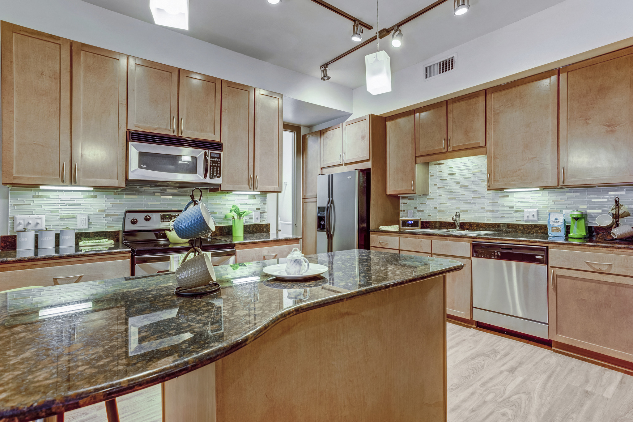a kitchen with wooden cabinets and granite counter tops