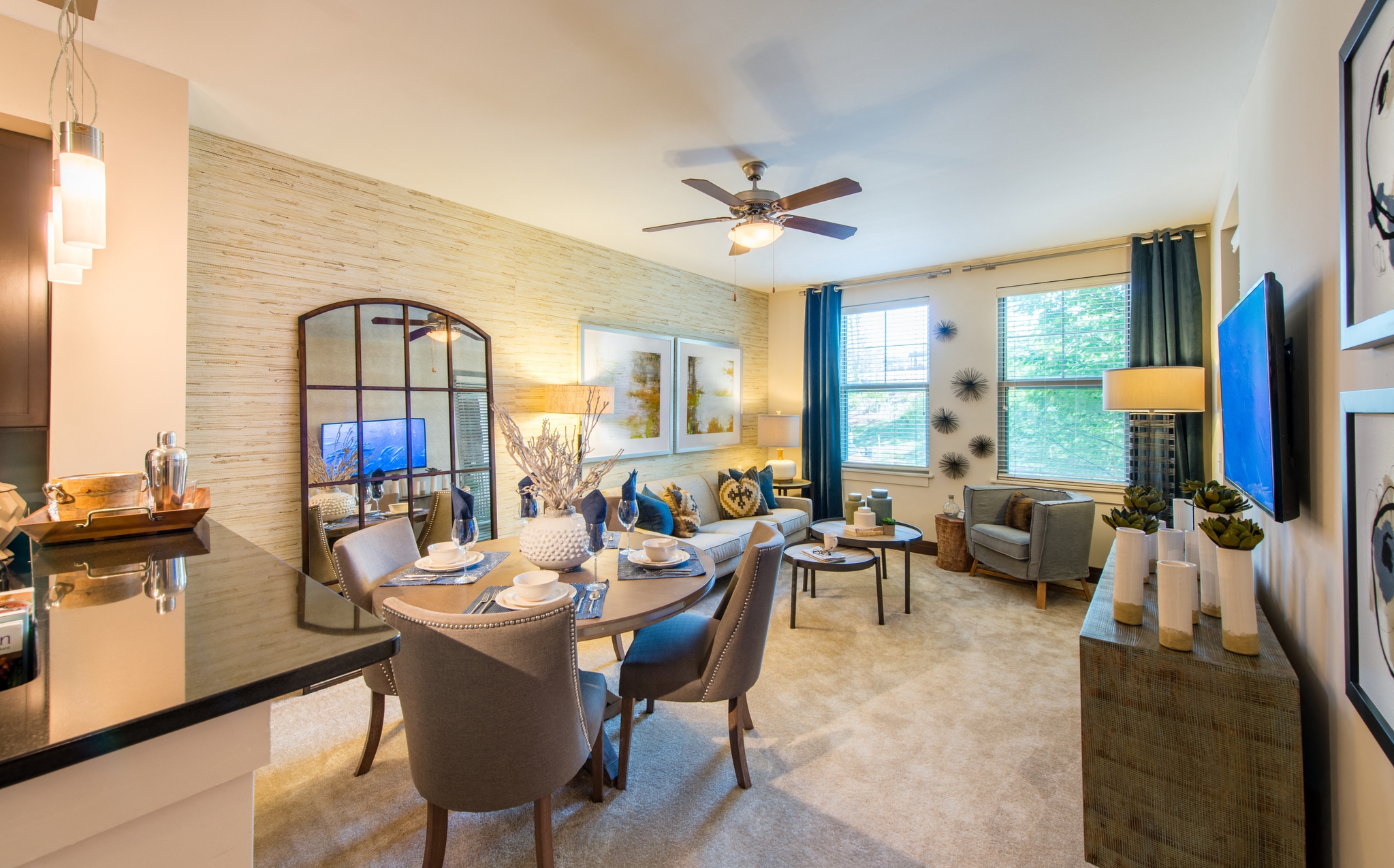 a living room with a dining room table and a ceiling fan