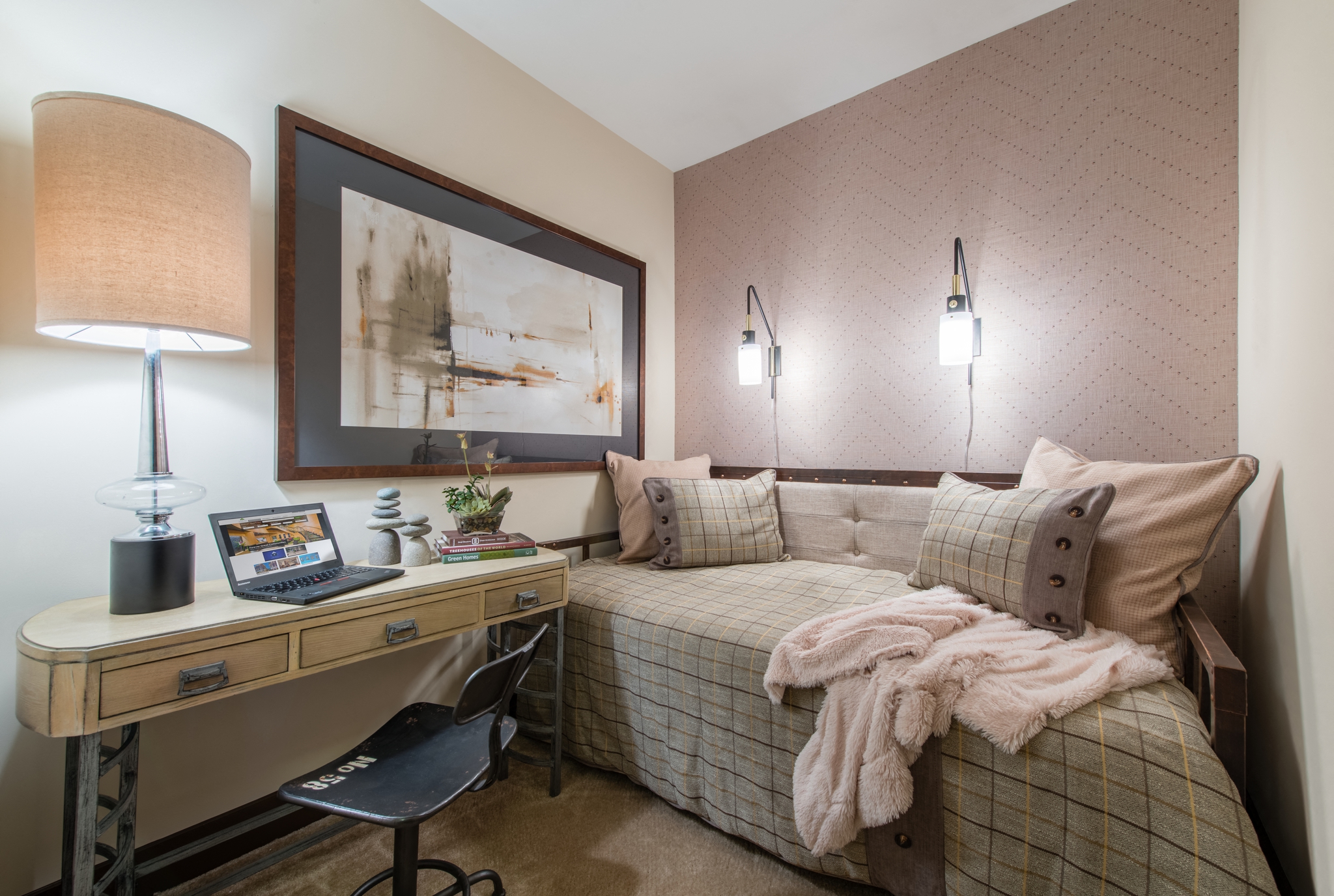 a bedroom with a bed and a desk with a laptop