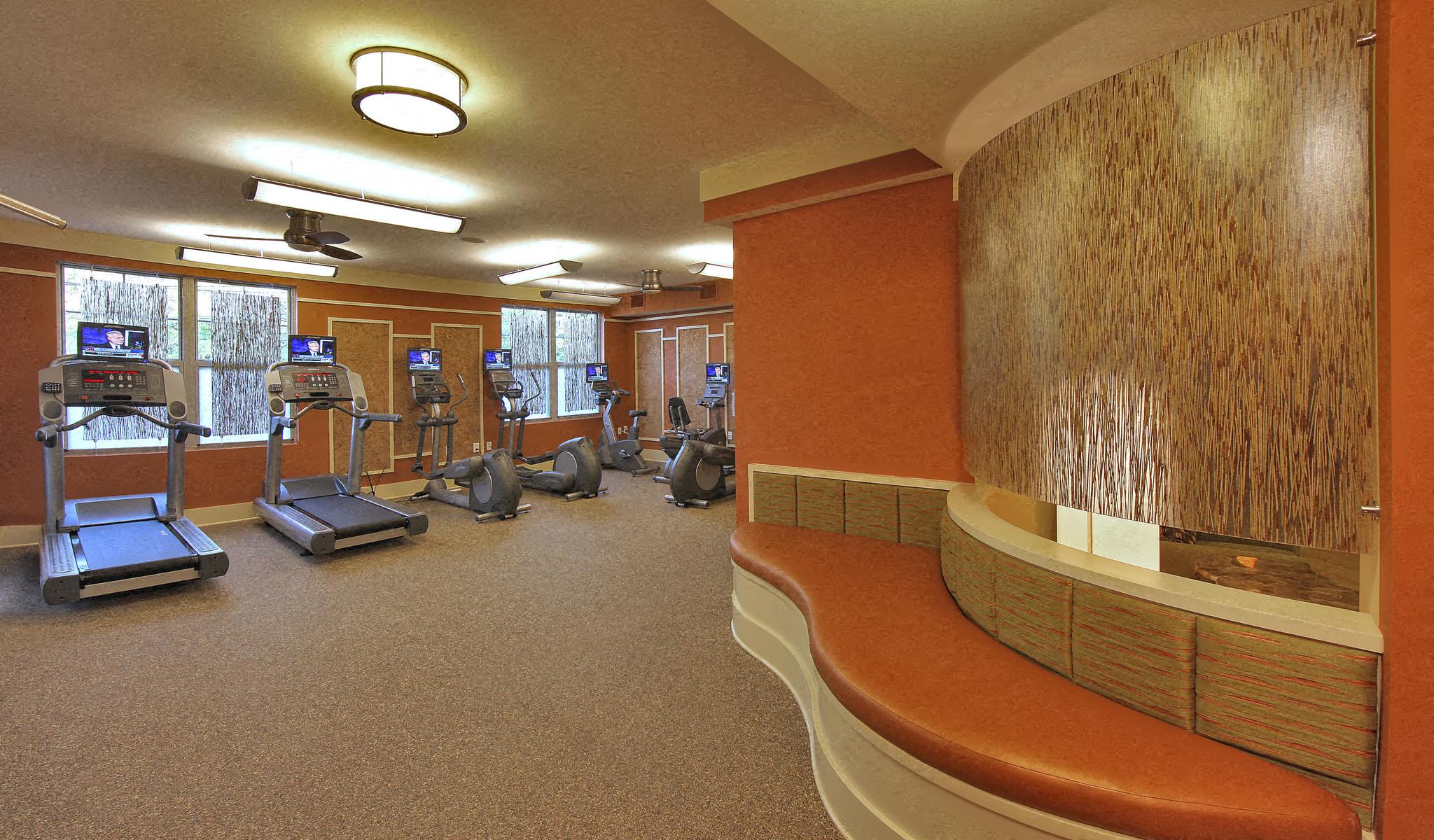 a gym with exercise equipment and a bench