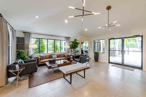 A spacious living room with a large window, a sofa set, and a coffee table.