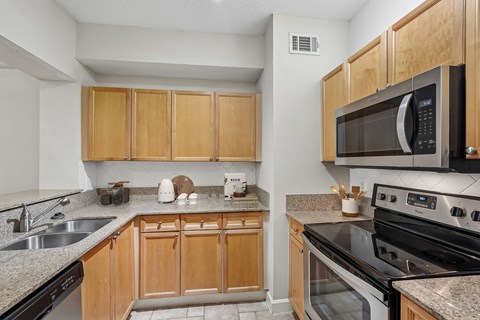 A kitchen with wooden cabinets and black appliances.