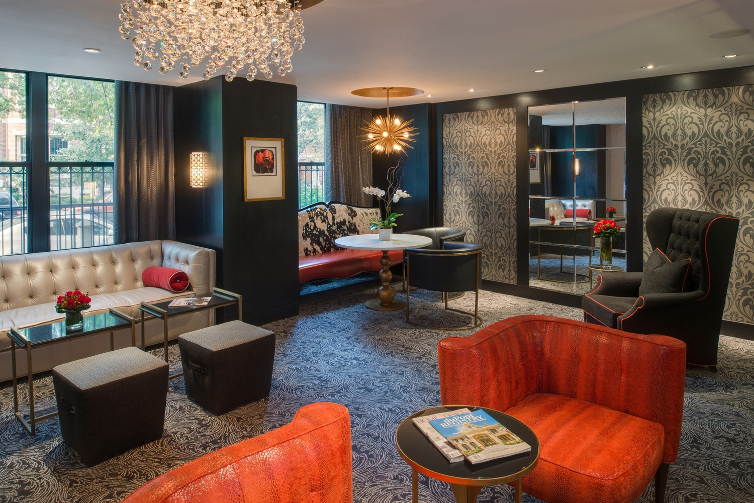 a lounge area with couches chairs and tables and a large window