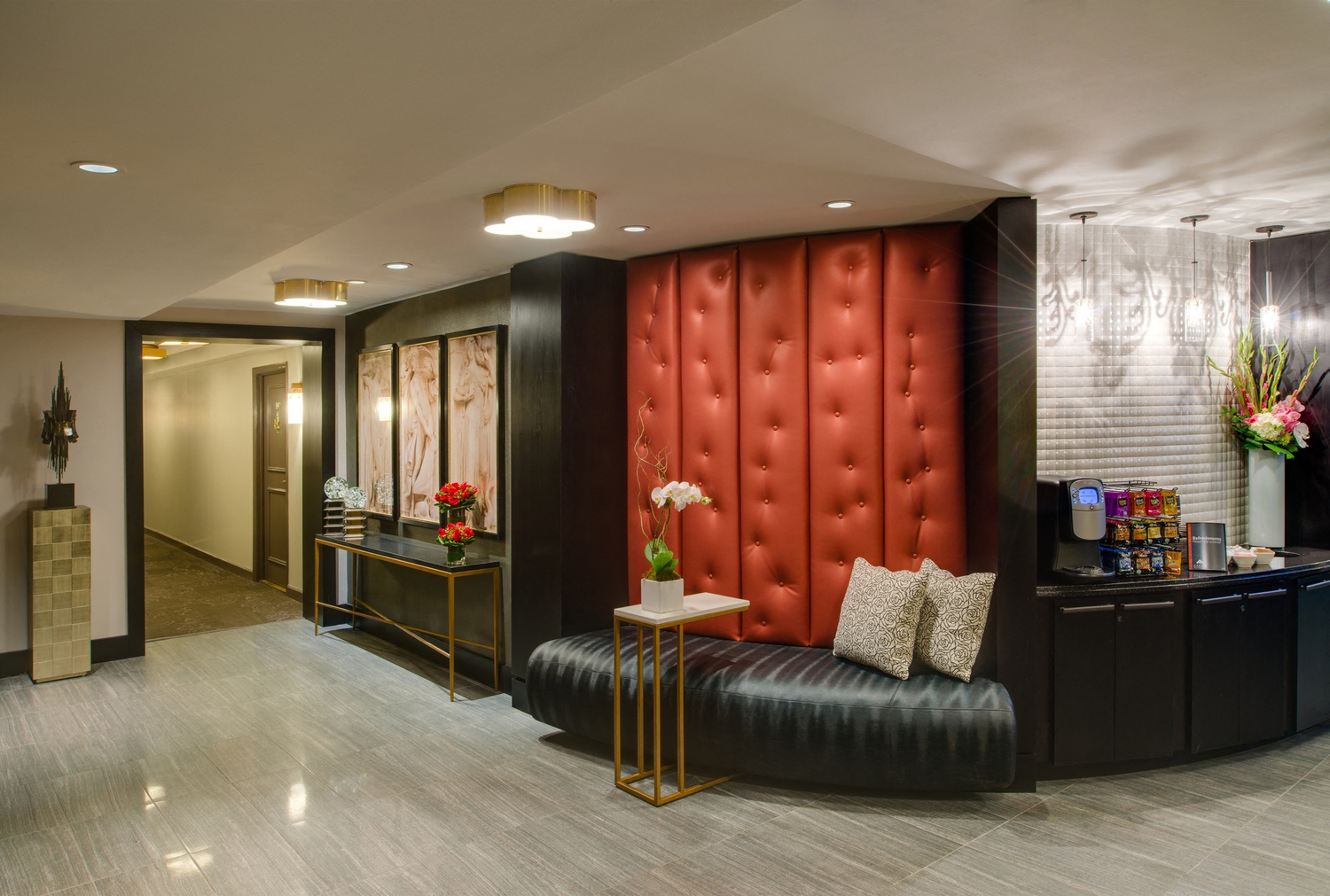 the lobby of a hotel with a red booth and a reception desk