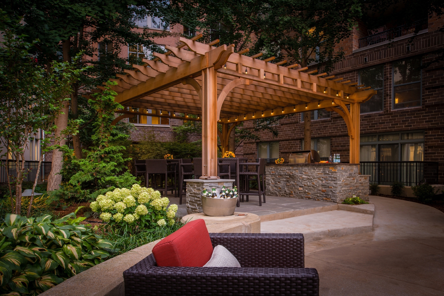 a patio with a wooden pergola and a table and chairs