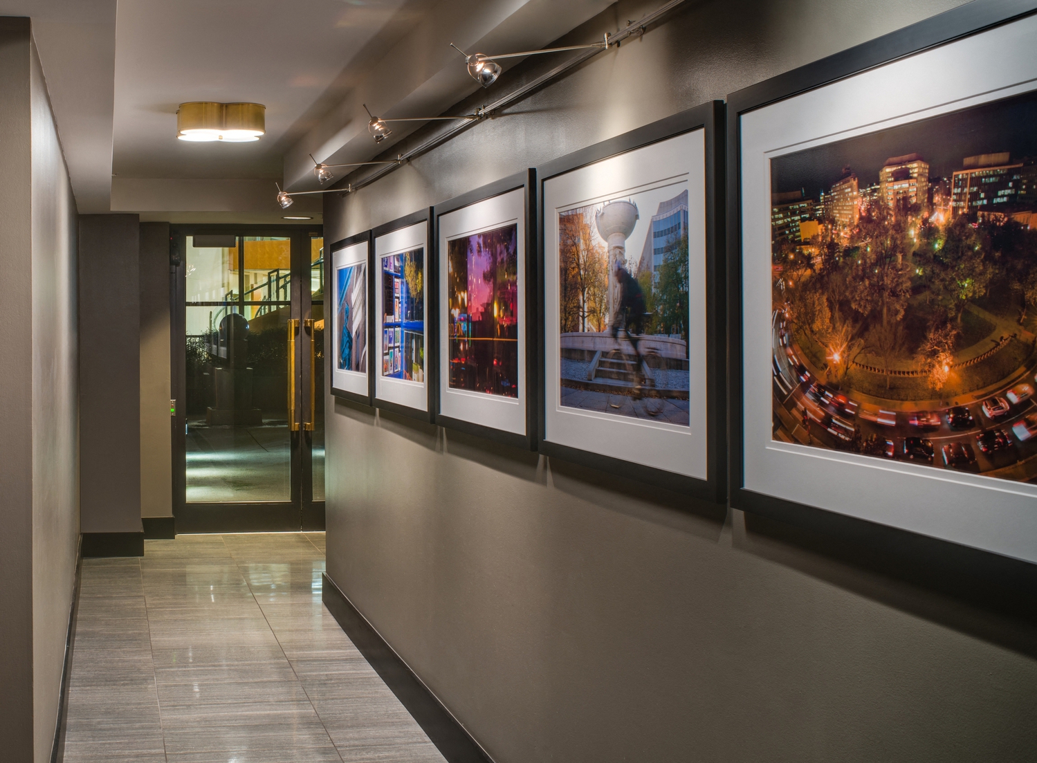 a row of pictures on a wall in a hallway of a building