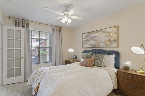 a bedroom with a large bed and a ceiling fan