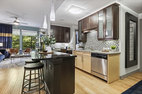 A modern kitchen with wooden cabinets and a black countertop.