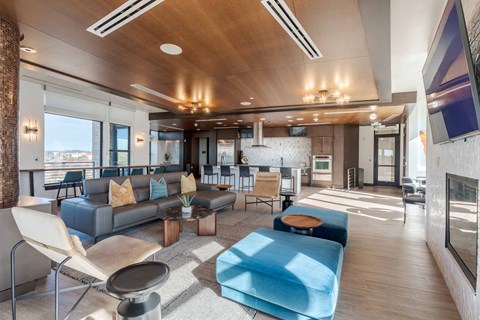 A modern living room with a grey sofa and a blue ottoman.