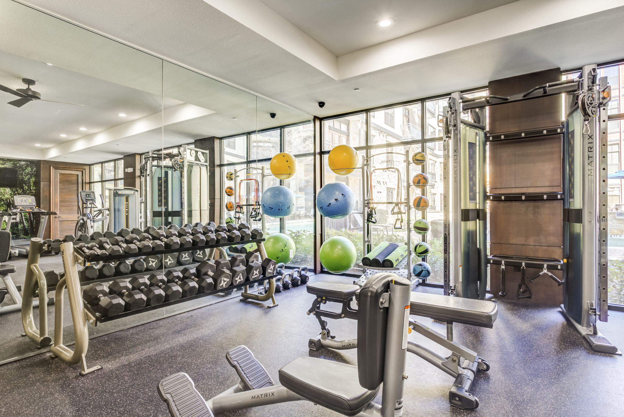 a gym with weights and other exercise equipment and windows