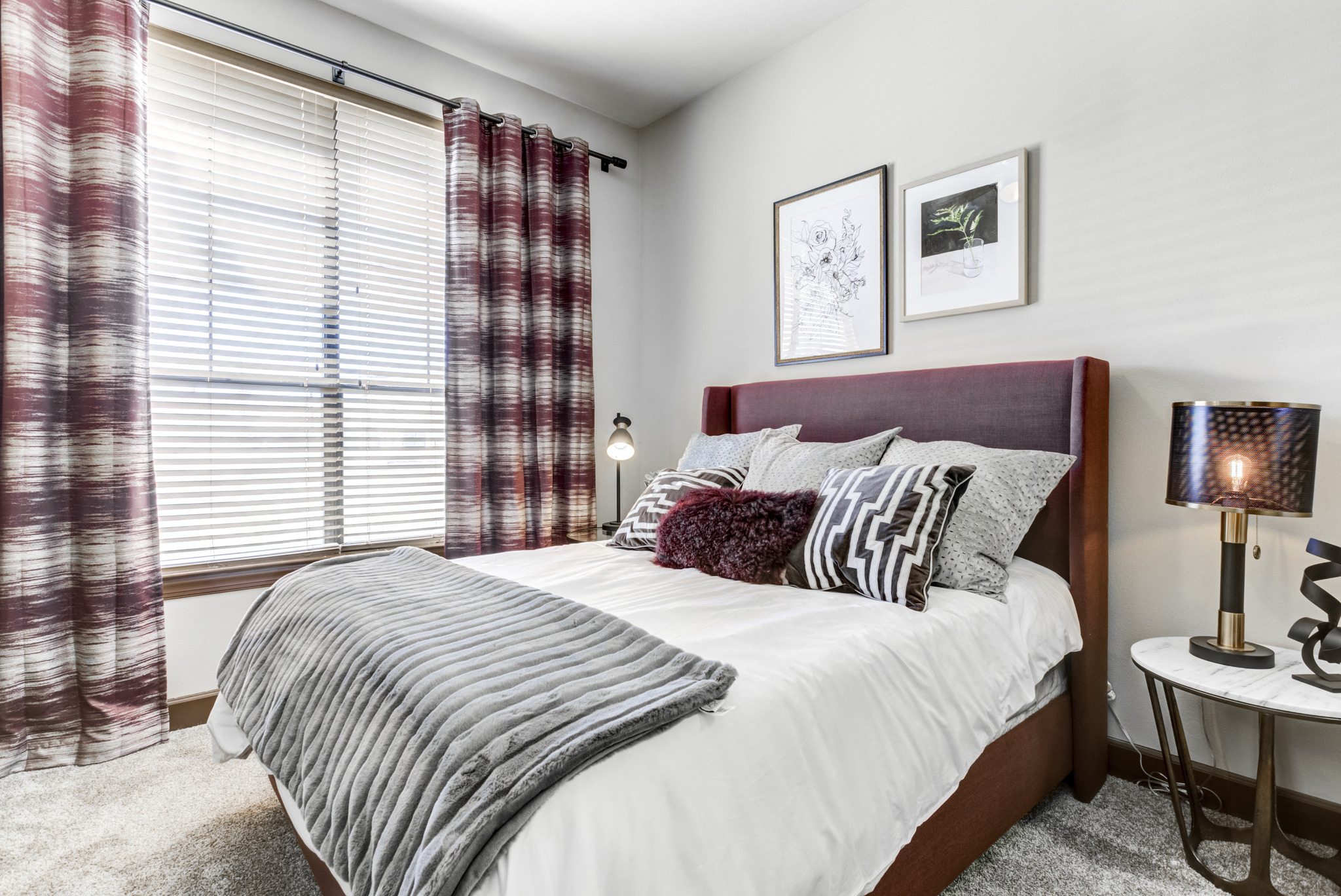 a bedroom with a bed and a window with blinds