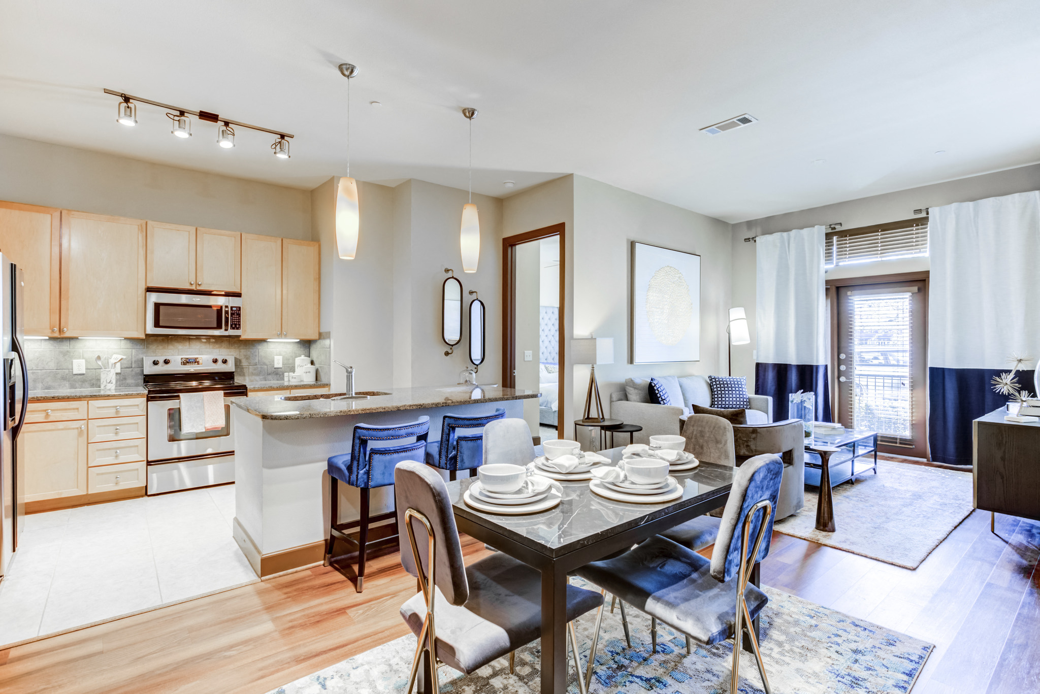 a living room with a dining room table and a kitchen