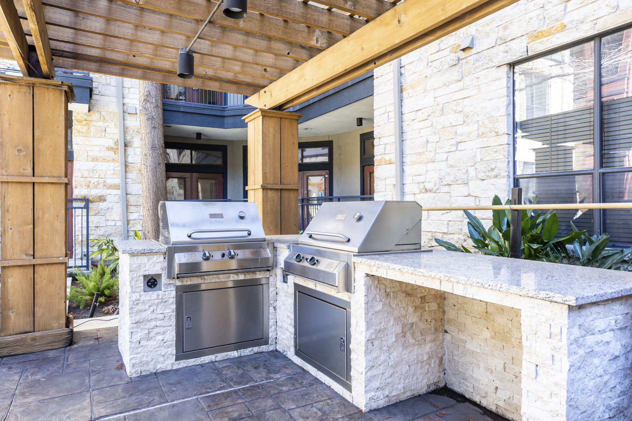 the outdoor kitchen has two stainless steel appliances and a bar