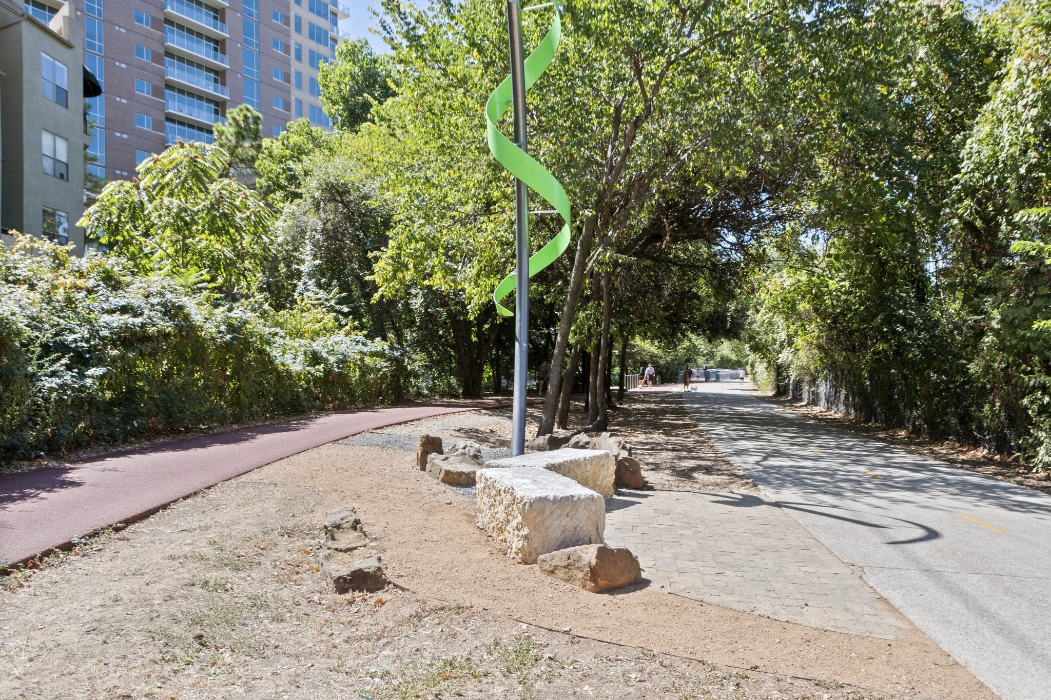 a green sculpture on a pole on the side of a street