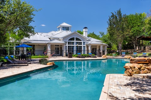 A large house with a pool in front.