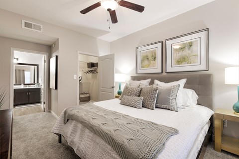 A bedroom with a large bed and a ceiling fan.