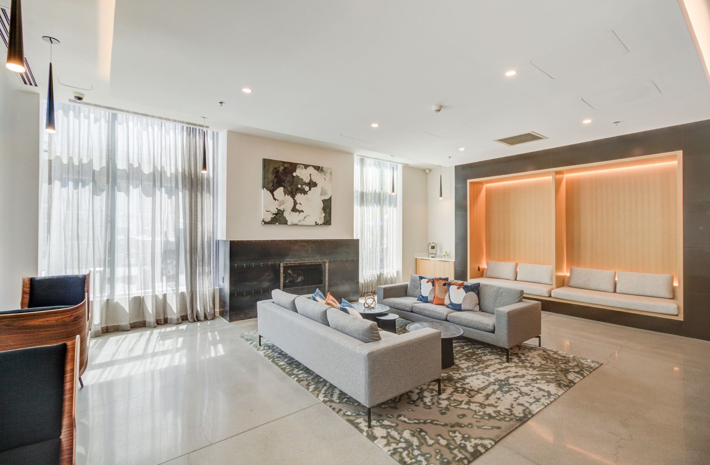 A modern living room with a fireplace and a large painting on the wall.