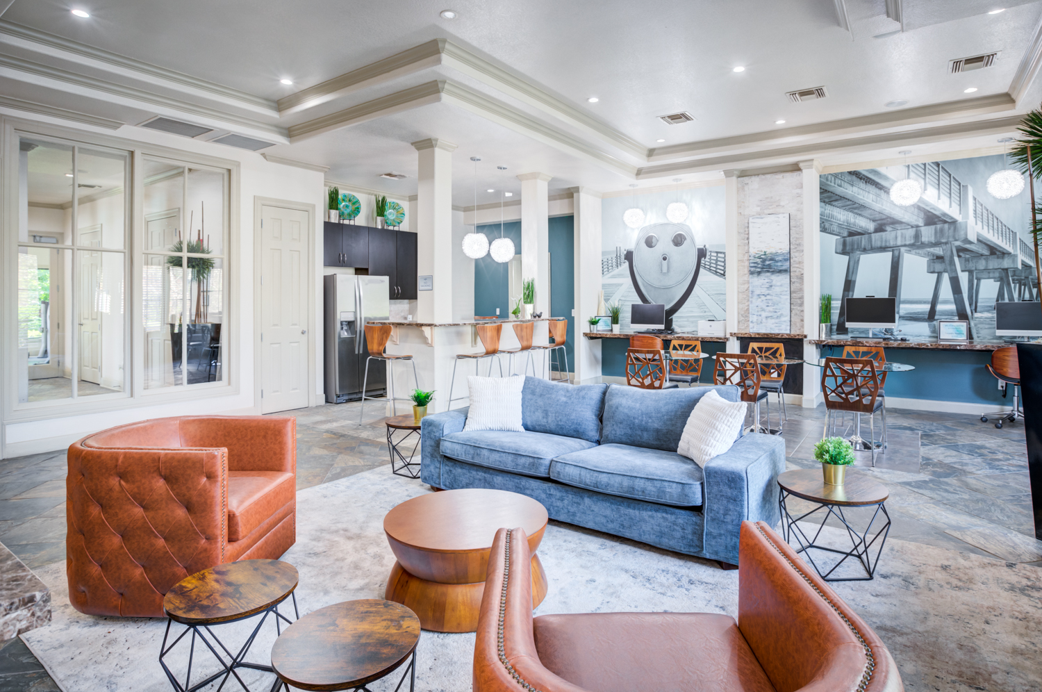 A living room with a blue couch and orange chairs.