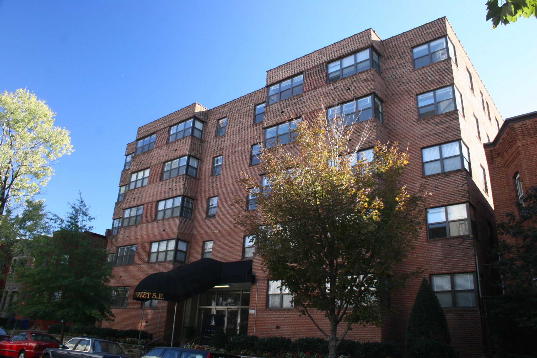 a large brick building with a tree in front of it