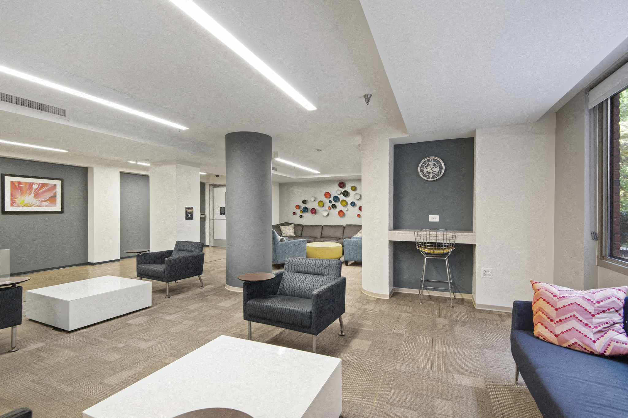 a large lobby with chairs and couches and a fireplace
