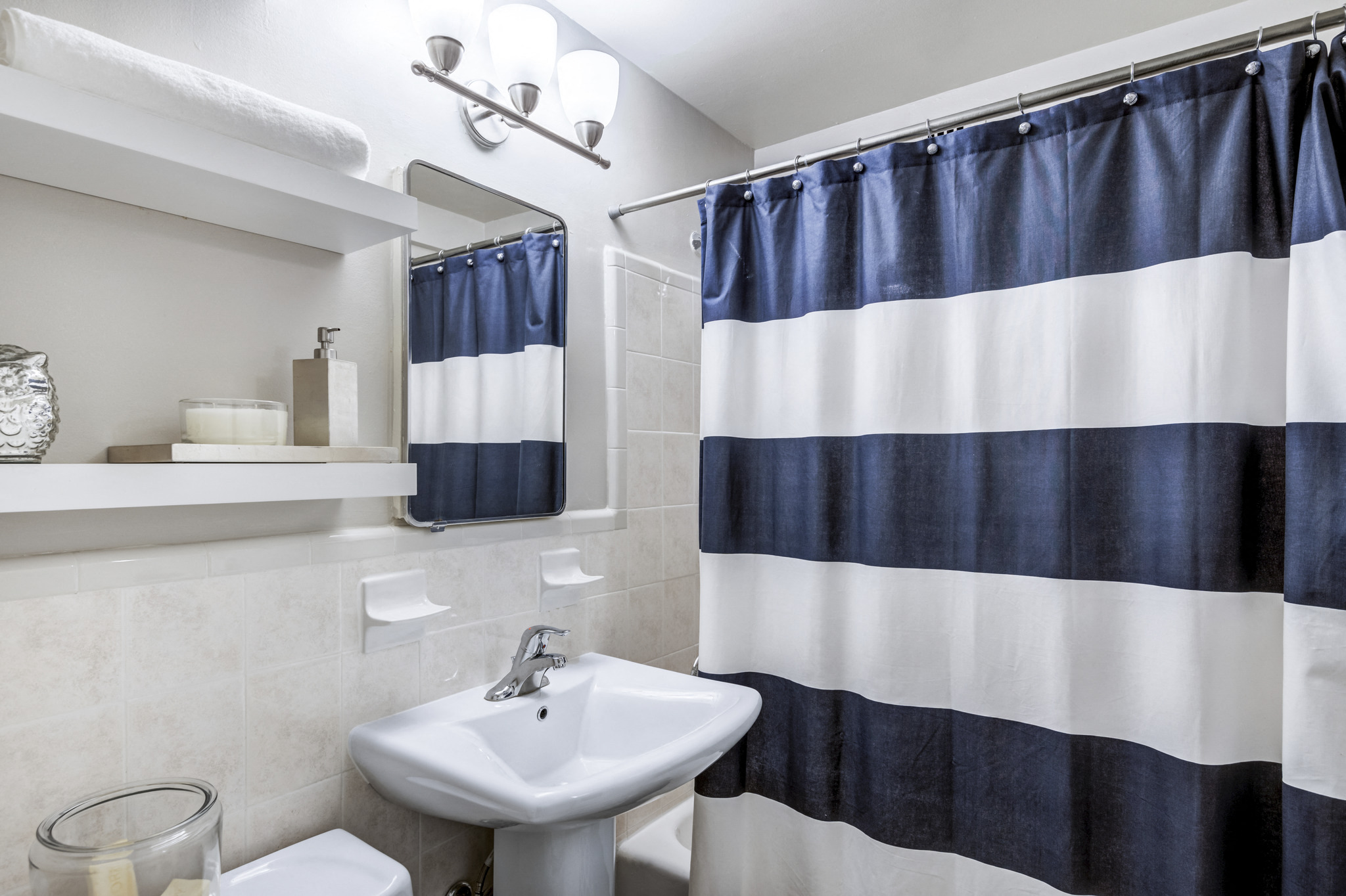 a bathroom with a blue and white shower curtain and a sink