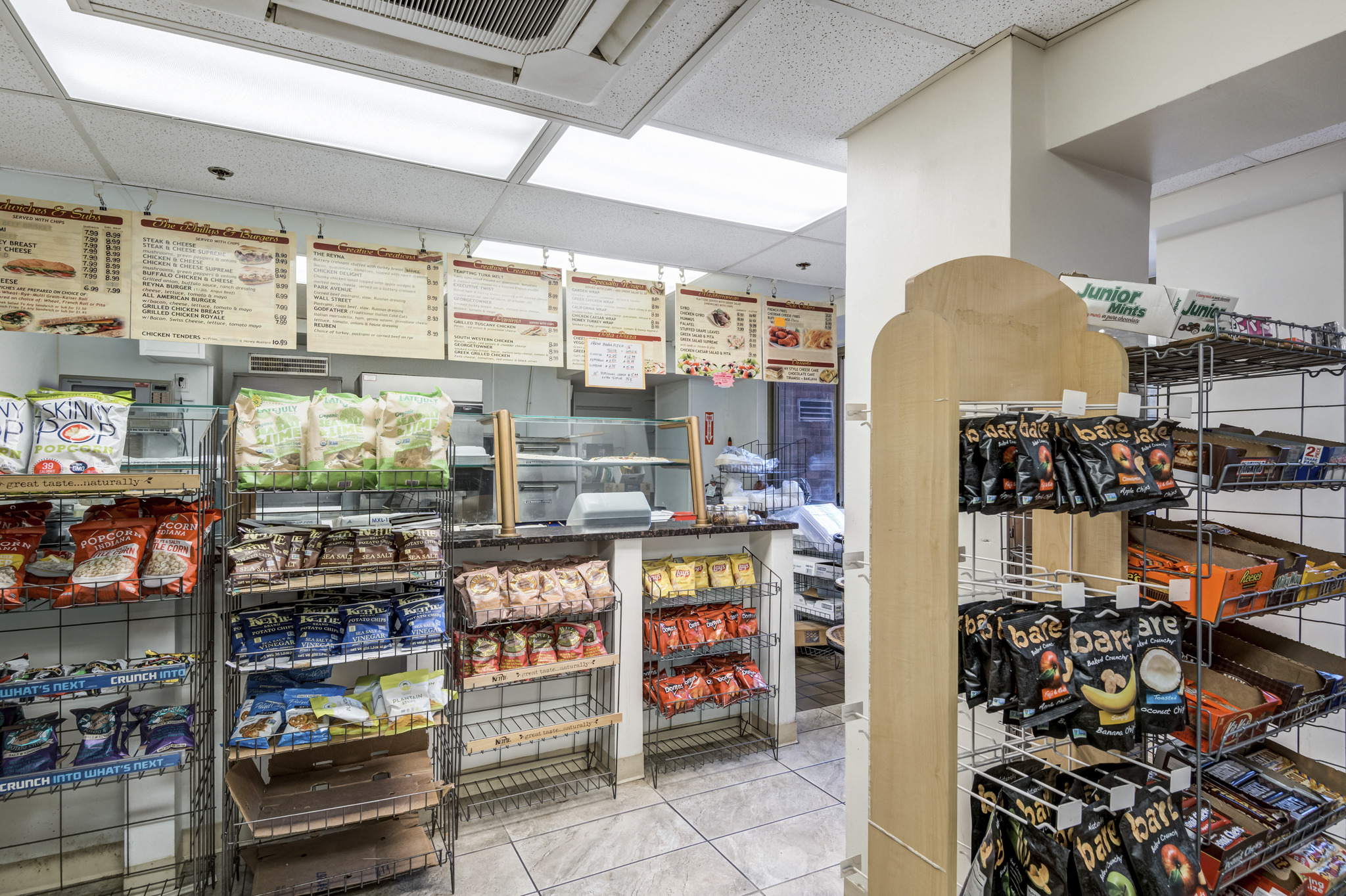 a grocery store with a large number of food items on display and a counter with