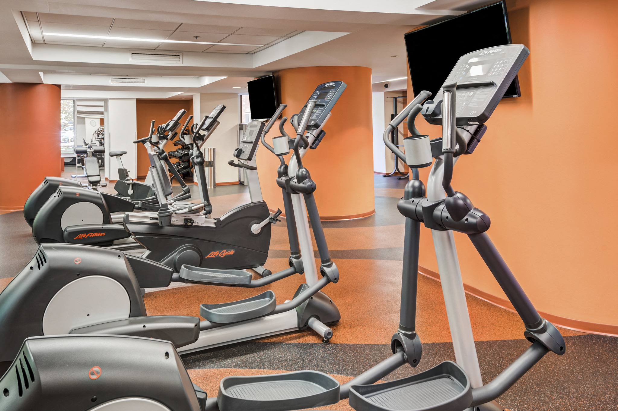 a gym with various exercise bikes and monitors on the floor