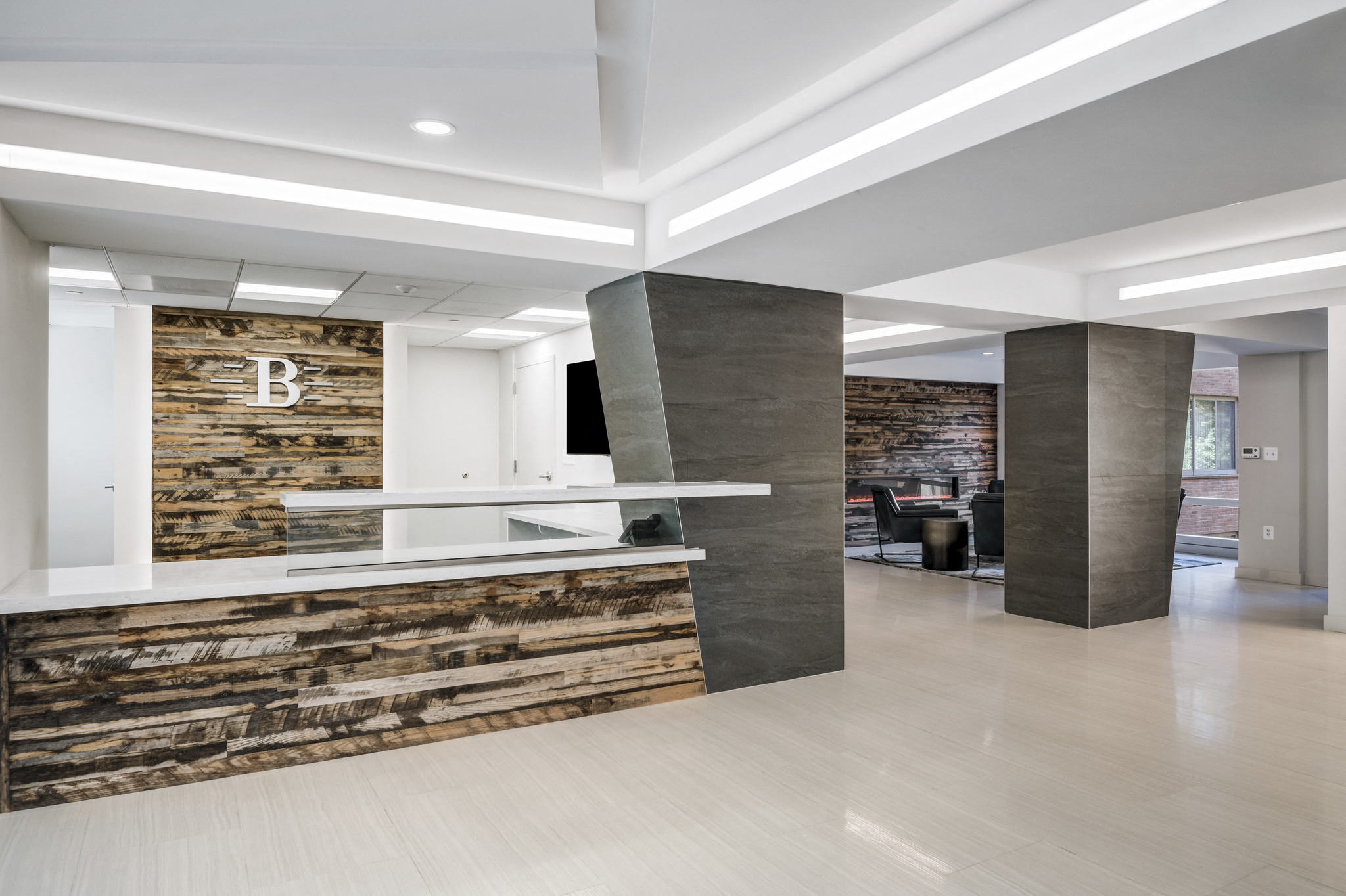a lobby with a reception desk and a brick wall