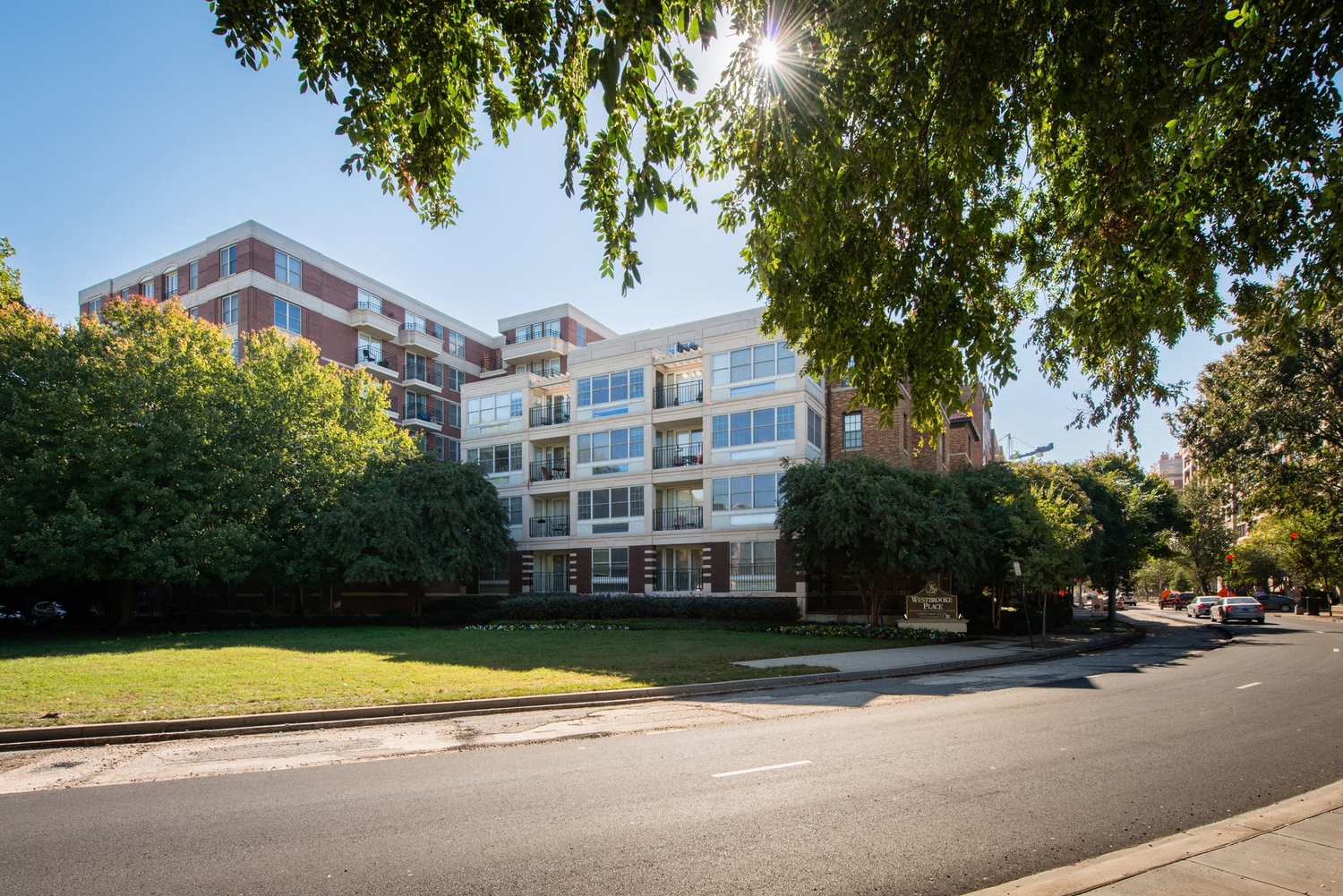a large apartment building on a street with trees