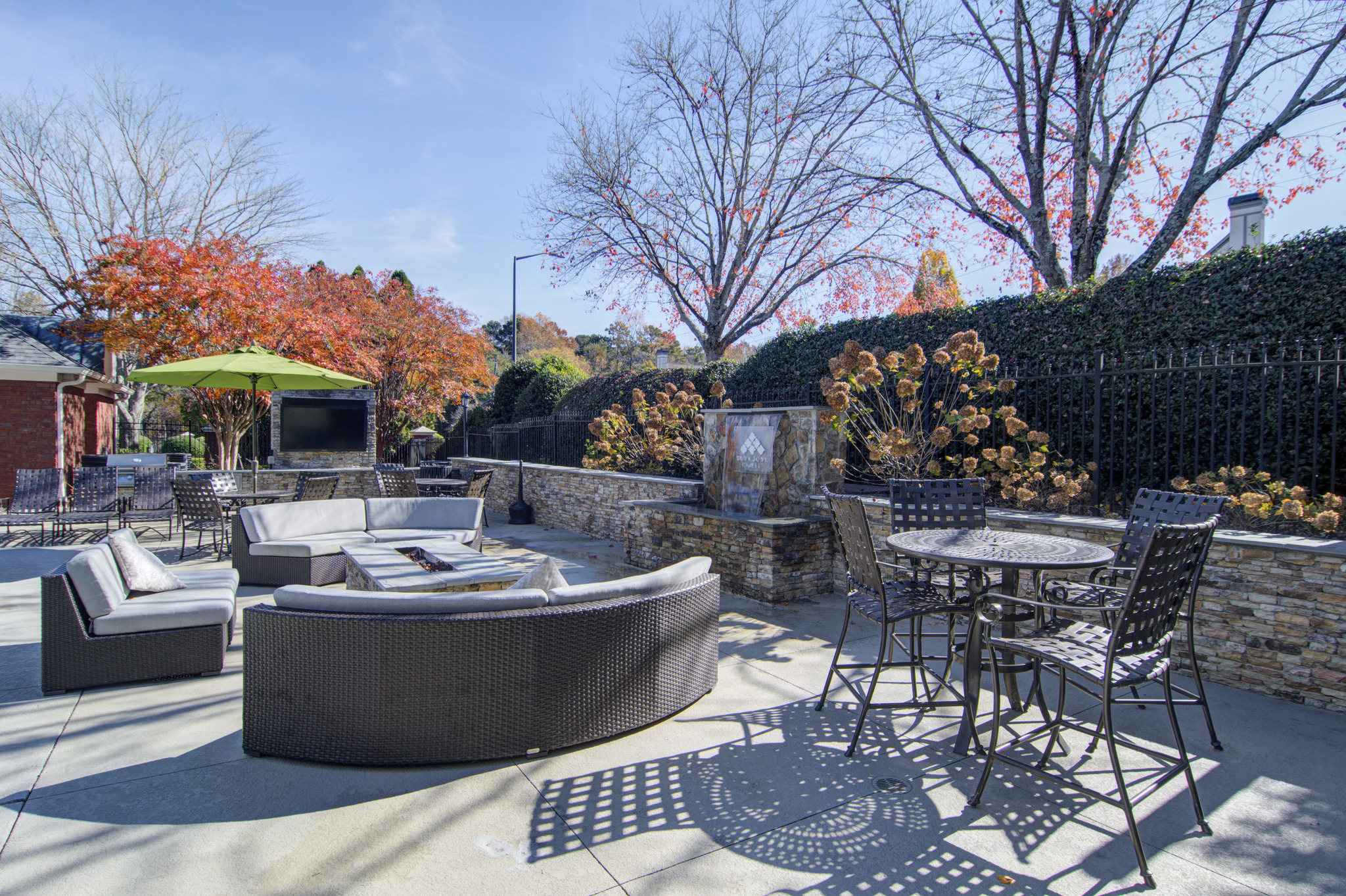 a backyard patio with chairs and tables and a fire pit