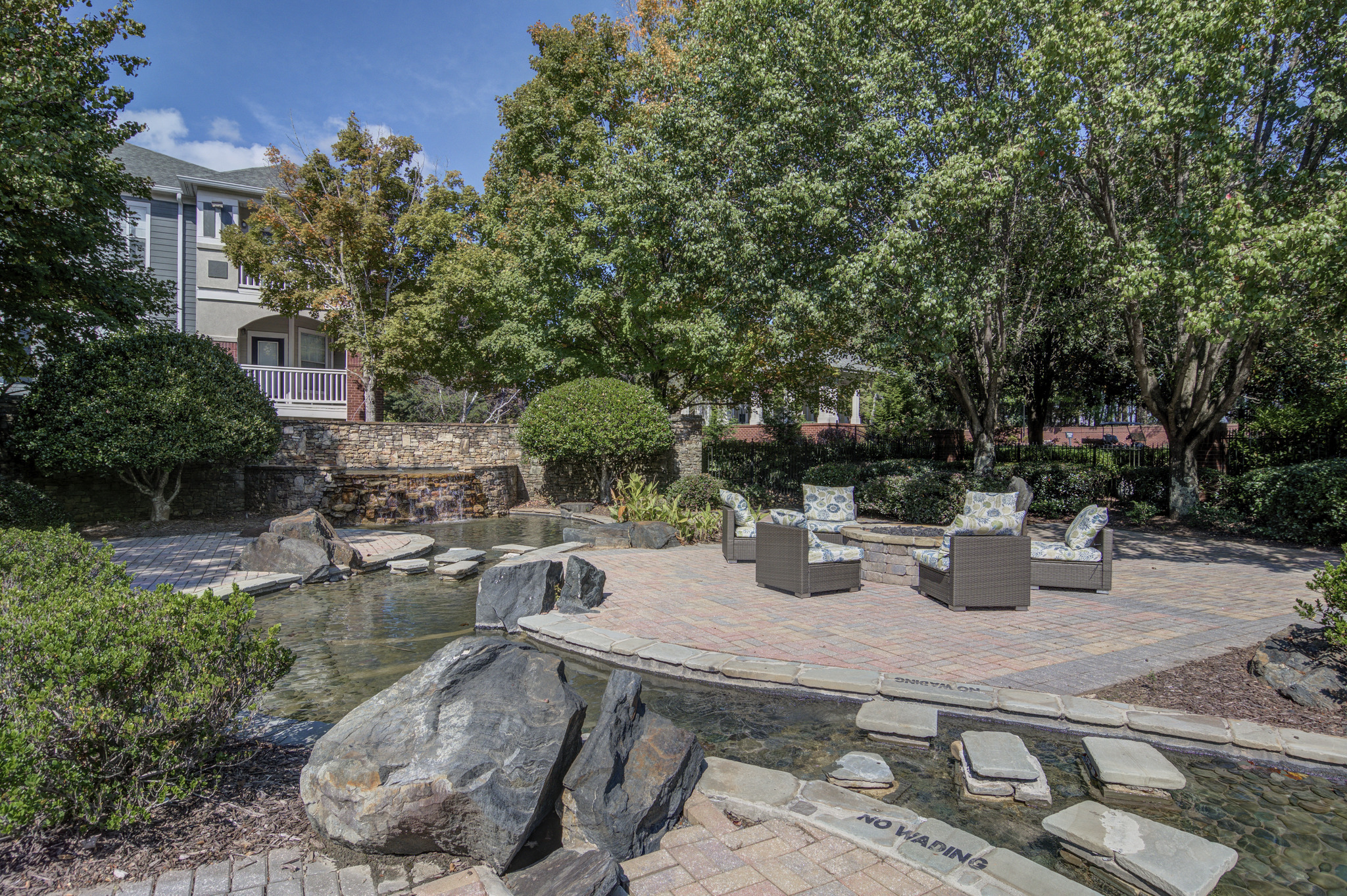a patio with benches and a water feature