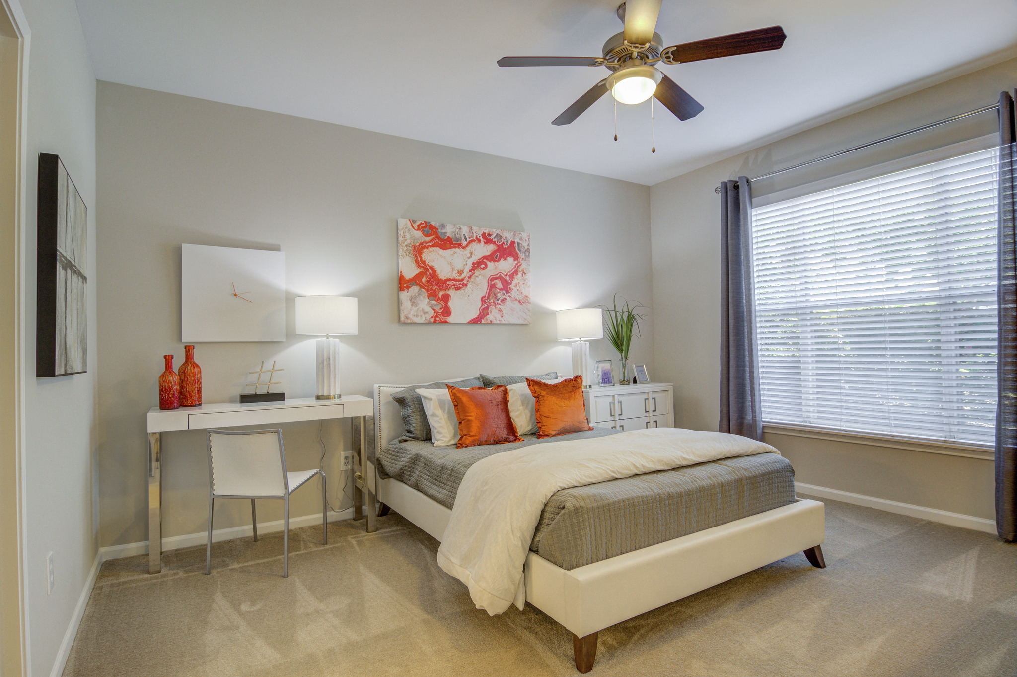 a bedroom with a bed and a desk and a ceiling fan