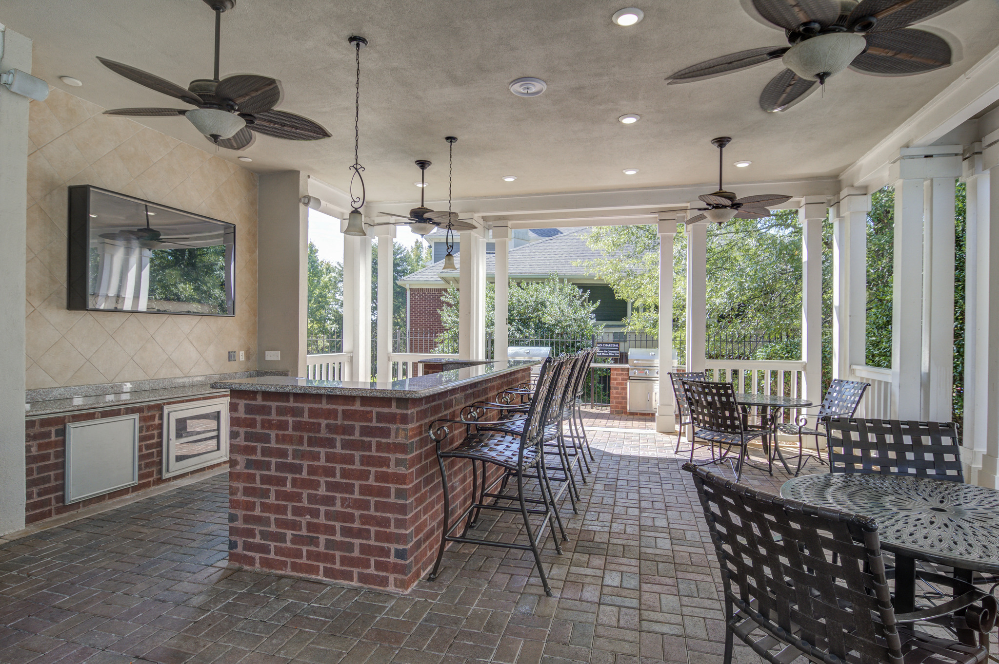 a covered porch with a bar and chairs and a table