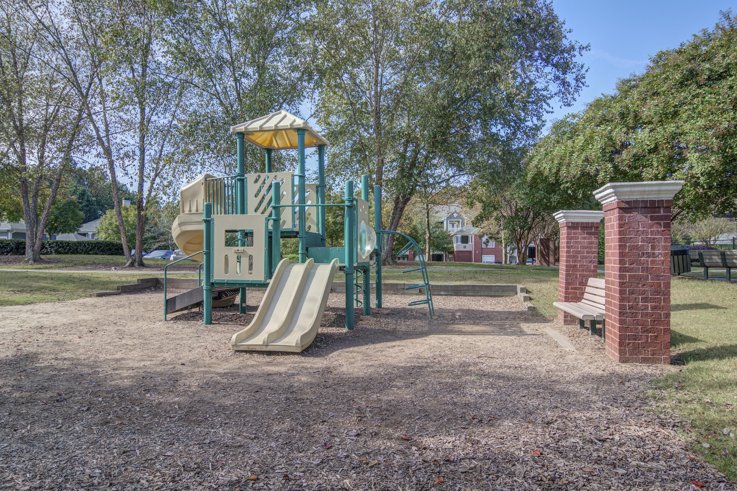 a playground with a swing set and slides in a park