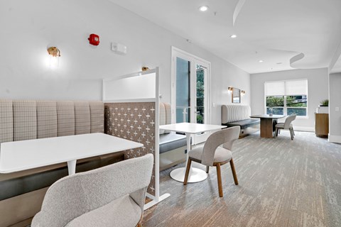 A modern dining room with a white table and chairs.
