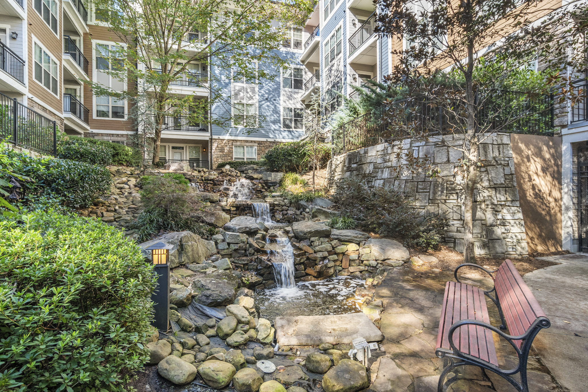 a creek running through a courtyard with a bench