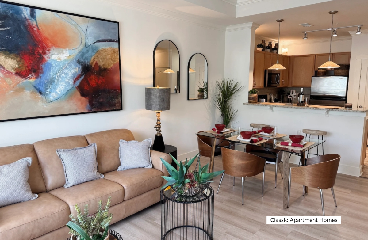 A living room with a couch, a table, and a painting on the wall.