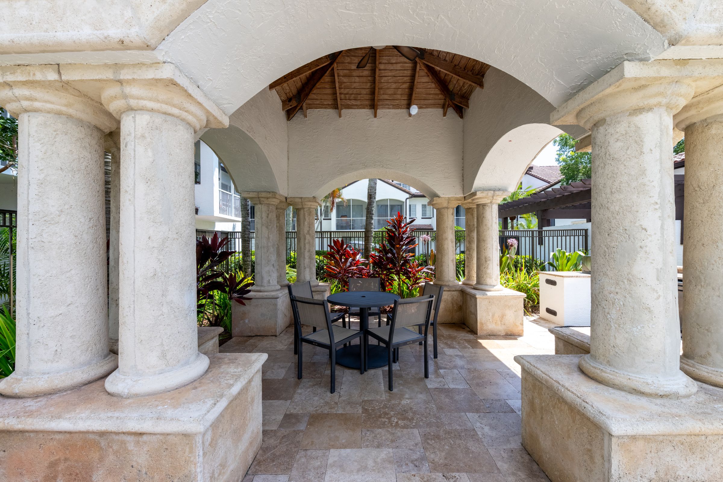 a patio with columns and a table and chairs