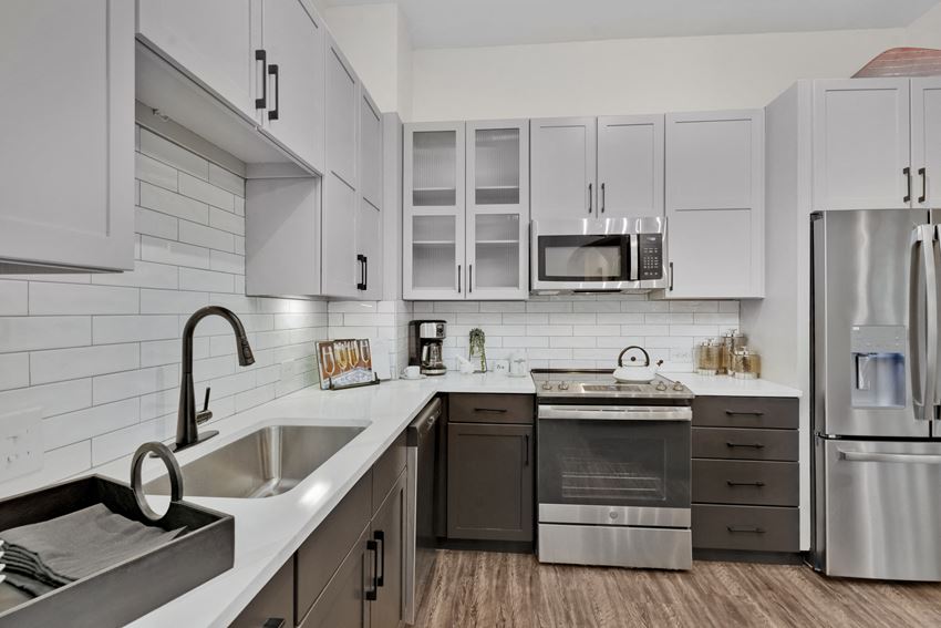 a kitchen with white cabinets and stainless steel appliances