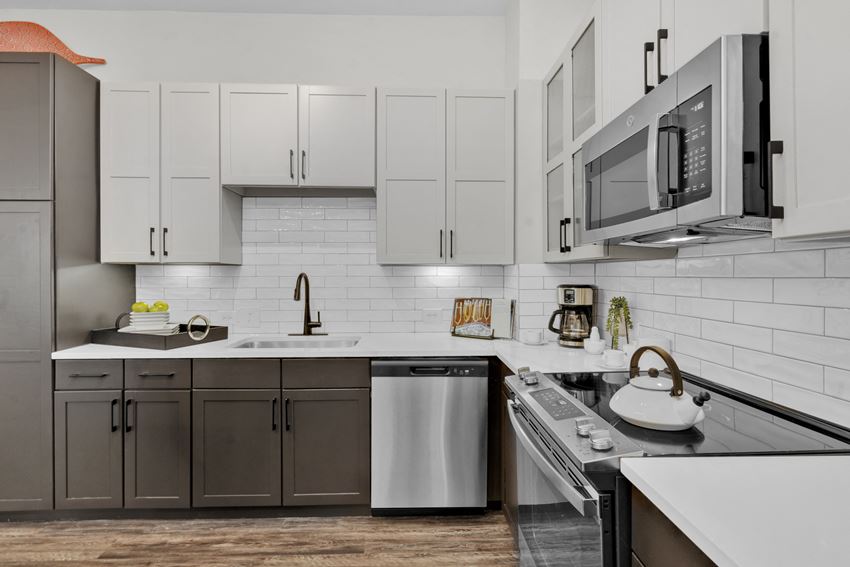 a kitchen with white cabinets and stainless steel appliances