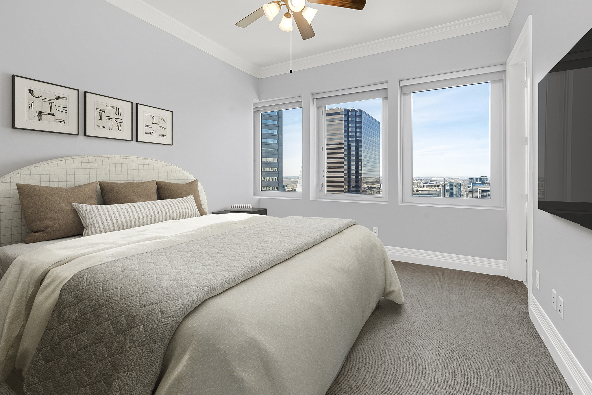 a bedroom with a large bed and three windows