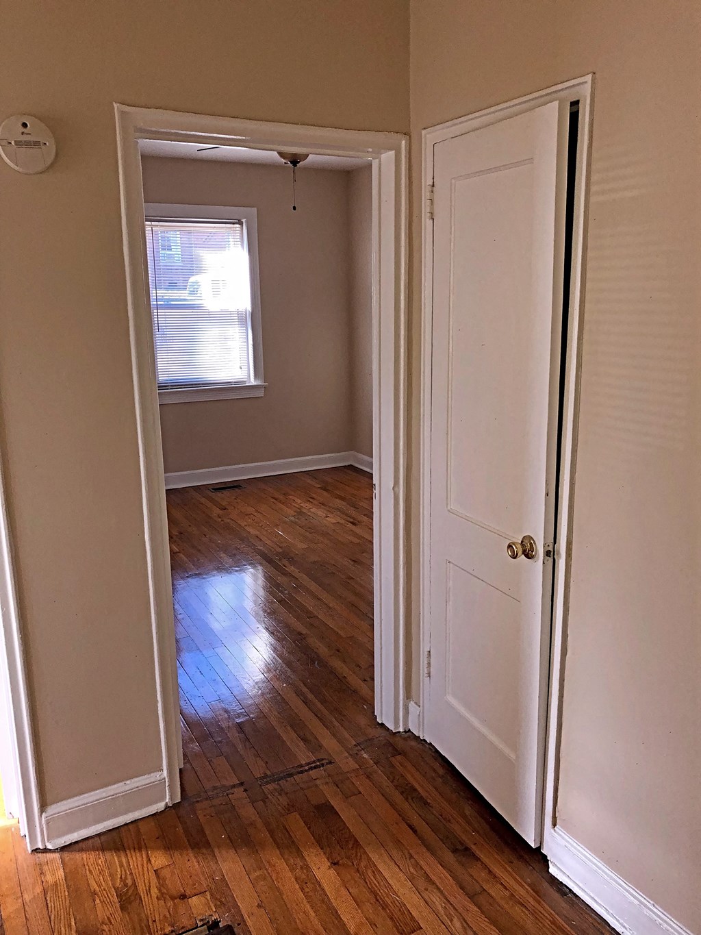 an empty room with a door open and a window