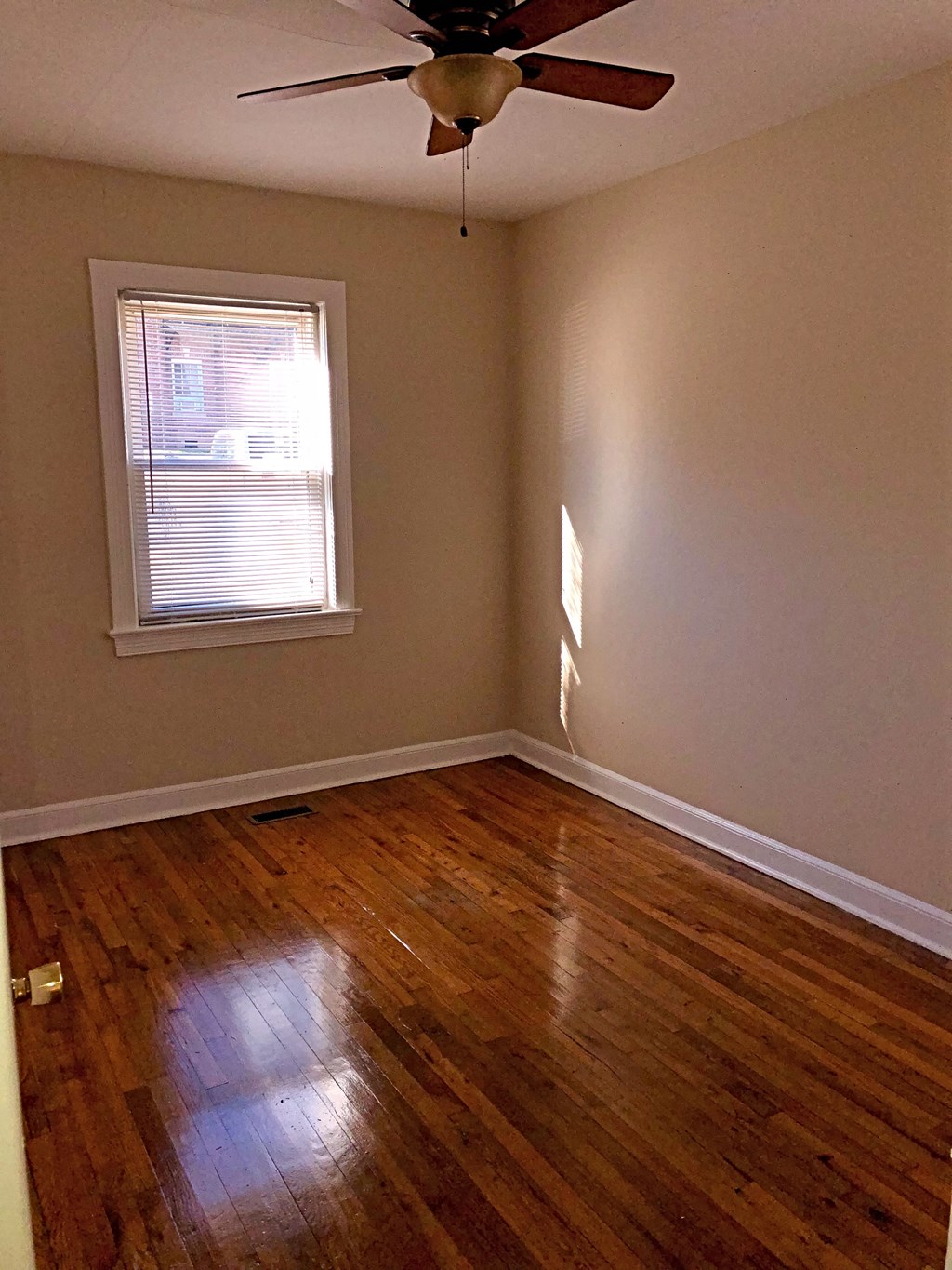 a empty room with a ceiling fan and a window