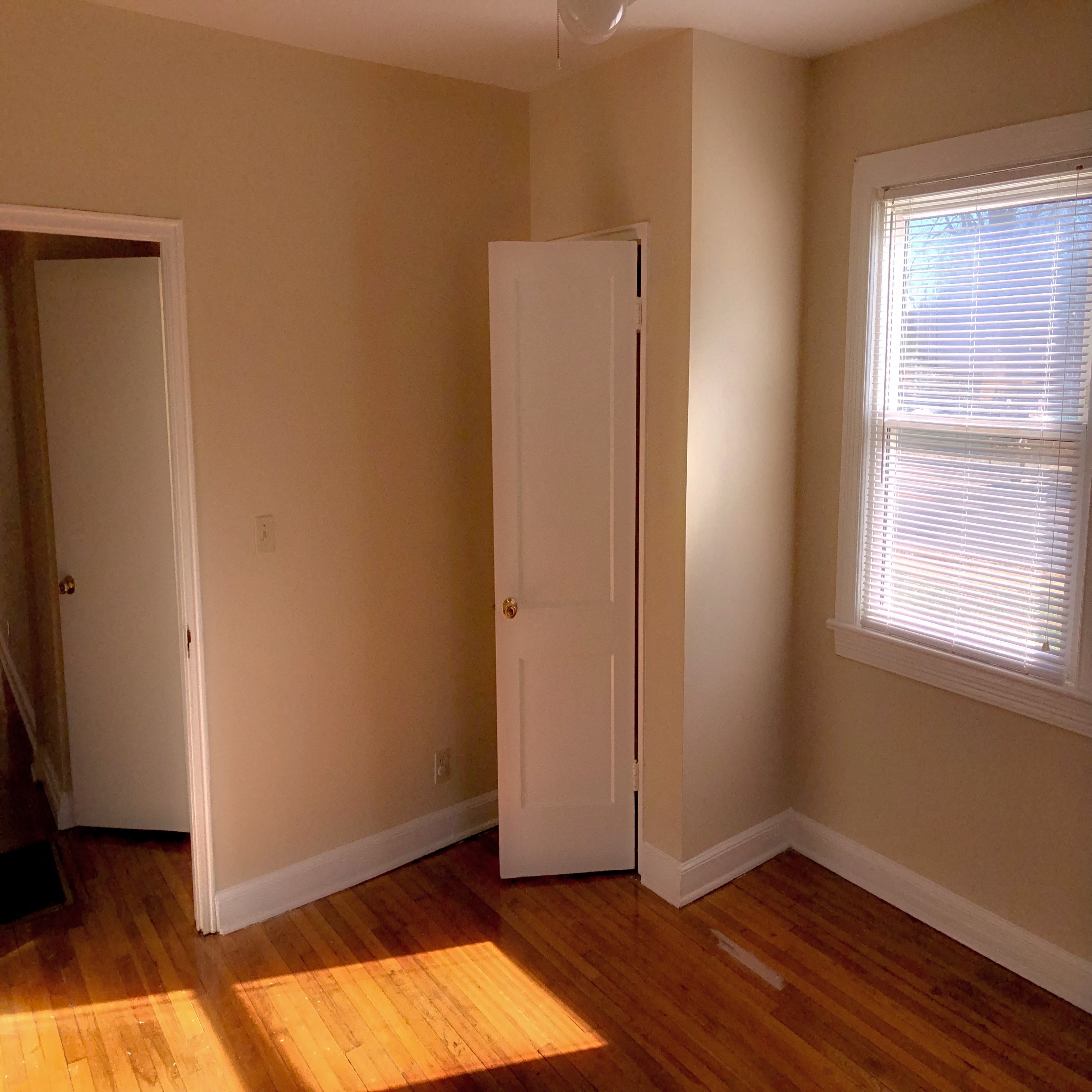 a room with a door and a window and a wood floor