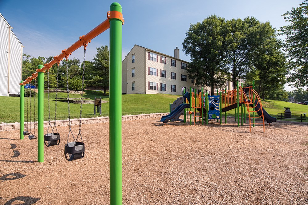 a playground in a park with a building in the background