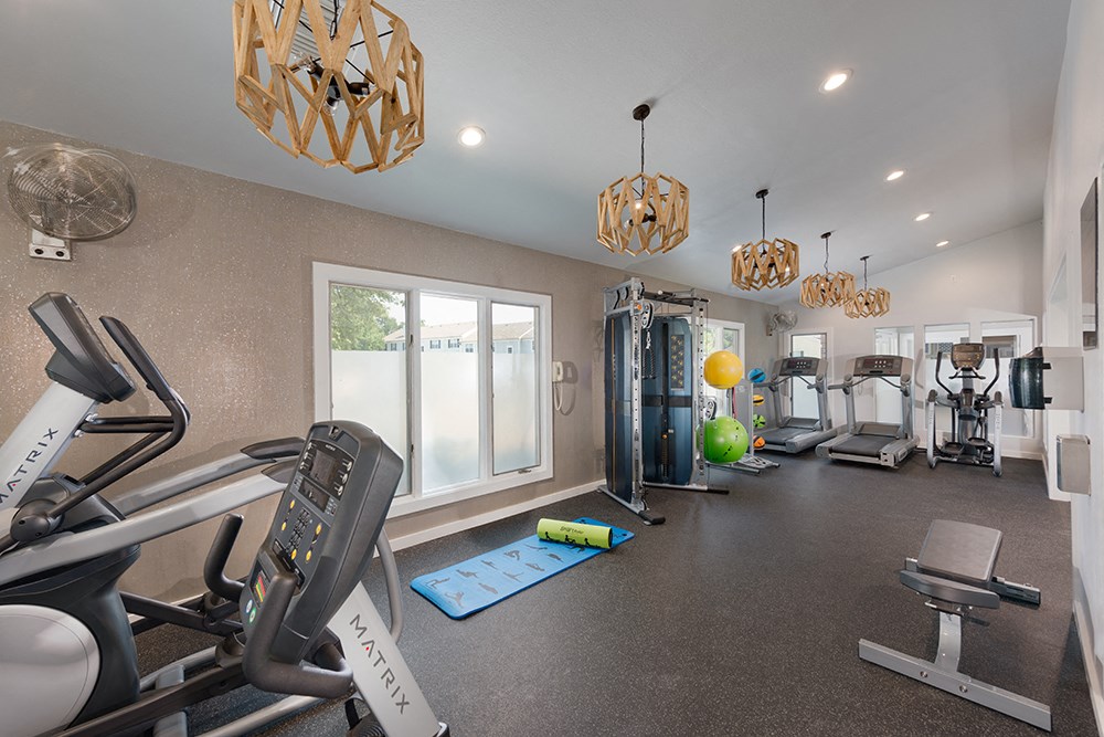 a gym with treadmills and other exercise equipment at the enclave at university heights