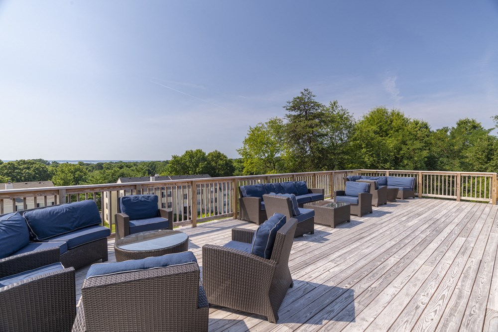 a large deck with chairs and tables overlooking the water